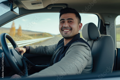 Portrait of smiling young man driving car. behind wheel looking at camera © Atchariya63