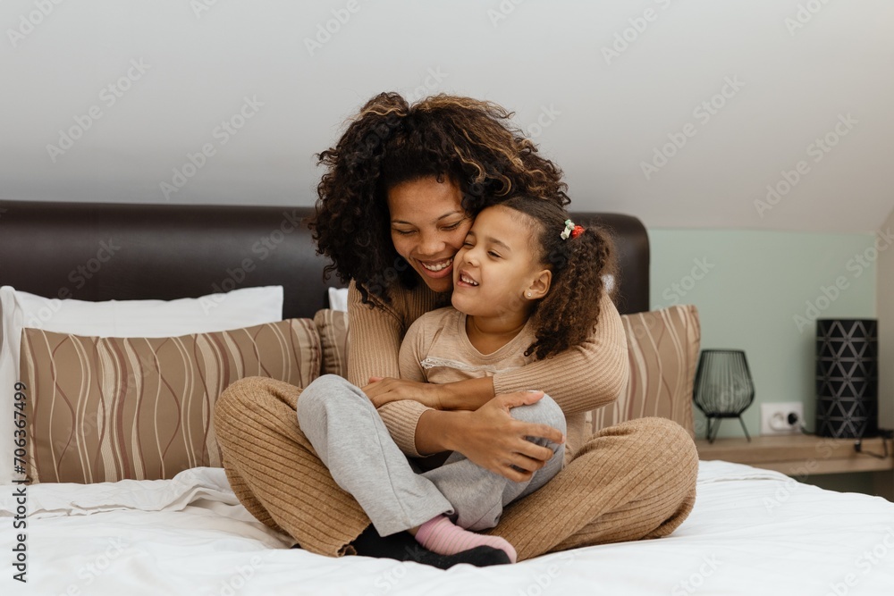 Togetherness Concept. Cheerful african american mother and daughter playing together on bed Togetherness Concept. Cheerful african american mother and daughter playing together on bed