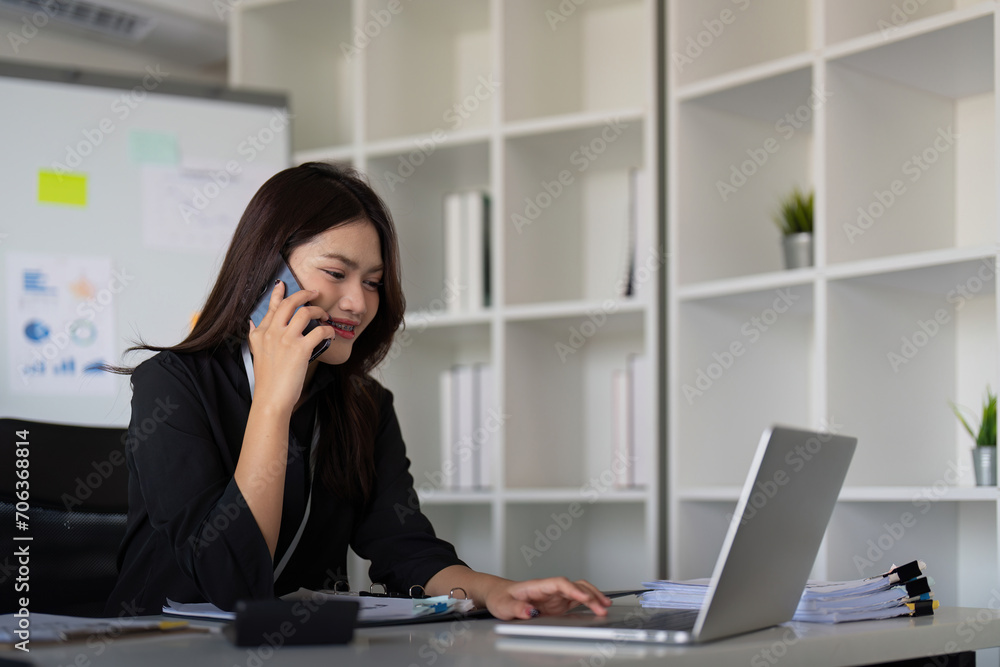 Happy confident businesswoman talking on the phone. Smiling female business person talking work using talking on the phone at office sitting at desk Happy confident businesswoman talking on the phone. Smiling female business person talking work using talking on the phone at office sitting at desk