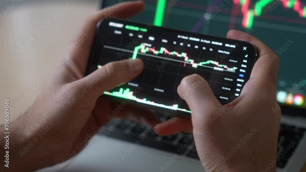 Smartphone with mobile application cryptocurrency wallet. A man analyzes the price chart for bitcoin in a mobile application. The concept of cryptocurrency trading Smartphone with mobile application cryptocurrency wallet. A man analyzes the price chart for bitcoin in a mobile application. The concept of cryptocurrency trading