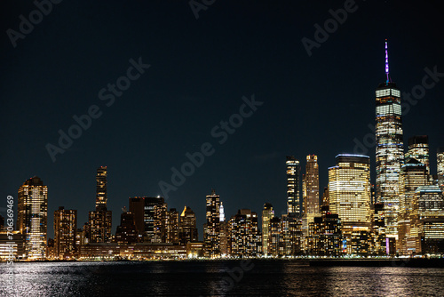 Stunning view of the New York City skyline at night, beautifully illuminated by lights © Wirestock
