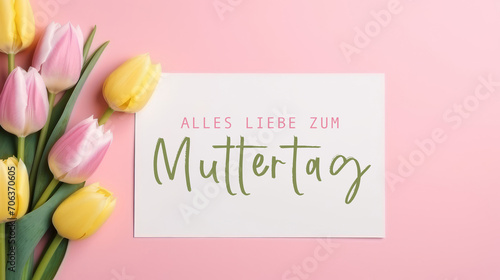 Alles Liebe zum Muttertag Feiertag Grußkarte - Weisses Papier, Rahmen mit deutschem Text und Tulpen auf pinkem Tisch Hintergrund, Draufsicht