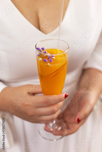 Bellini with prosecco and a peach outdoors. Woman holding a glass outdoors photo