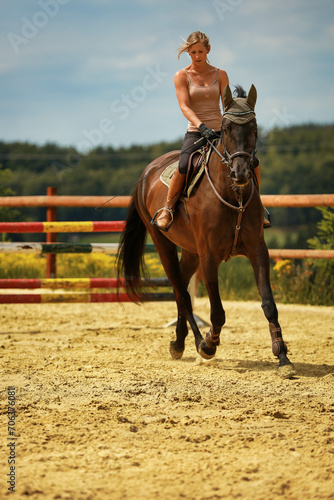 Young blonde girl woman with horse on the riding arena in summer. © RD-Fotografie