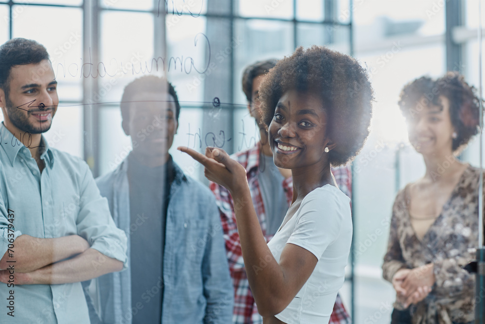 Obraz premium a team of young designers sticking notes on glass in a modern office