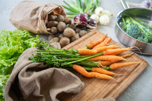 Organic carrots, potatoes  layout. Vegetables fresh from the garden with concrete background.