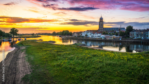 Scenic view of the town of Deventer along a river in the Netherlands at sunset photo