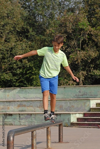 playful kid walking balancing on a metal tube on urban park background. © Gustavo Andrade