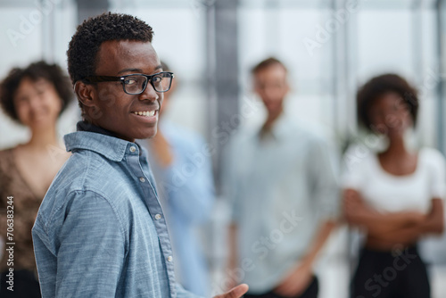smiling African American business man with executives working in background