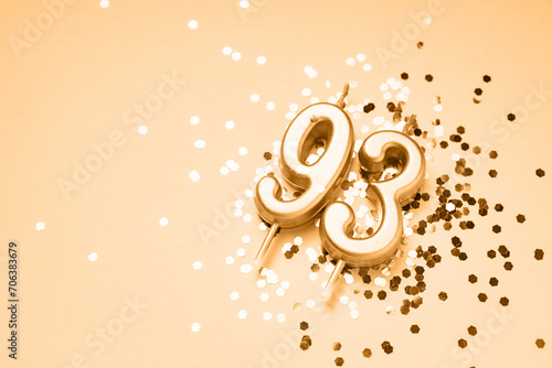 93 years celebration festive background made with golden candles in the form of number Ninety-third lying on sparkles. Universal holiday banner with copy space.