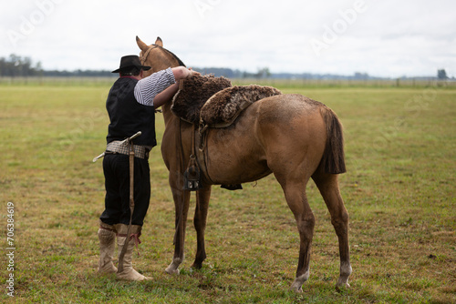 gaucho hugging his horse in the middle of the field