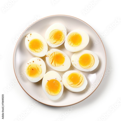 Plate with cut boiled eggs on white background