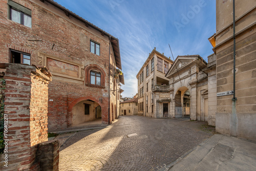 Carignano, Italy -  view of via Monte di Pieta with old medieval house with fresco and neo-baroque portal of the former Bona & Delleani woolen mill (early 20th century) photo
