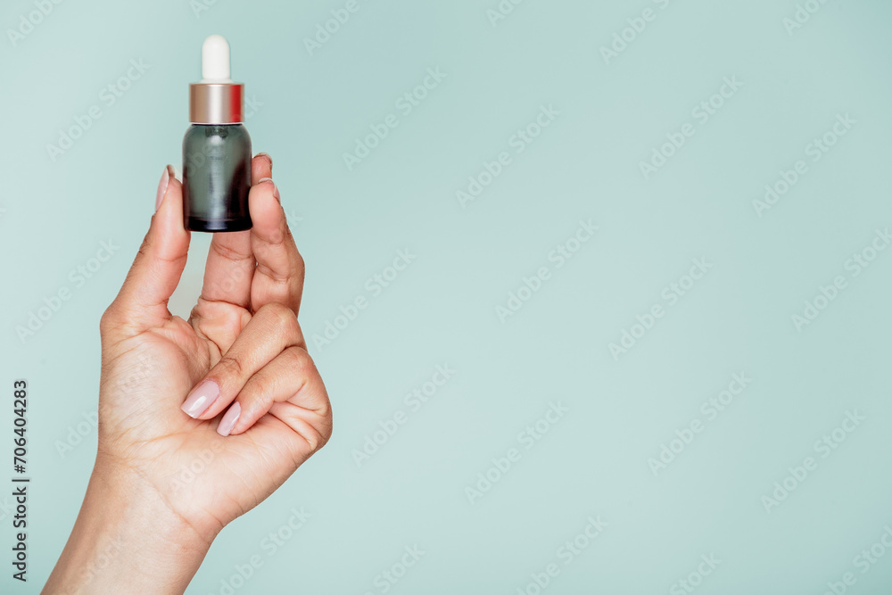 Isolated hand with a blue bottle on a light English blue background Isolated hand with a blue bottle on a light English blue background