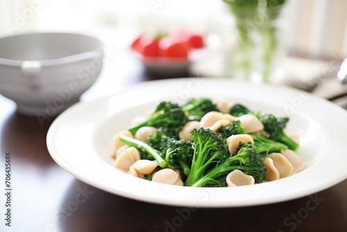 orecchiette with bright green broccoli rabe on white plate photo