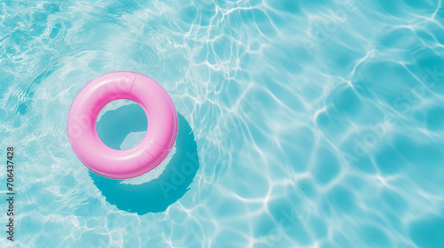 Fototapeta Naklejka Na Ścianę i Meble -  Pink pool float ring floating in a refreshing blue swimming pool. Top view