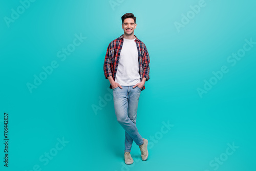 Full length photo of cheerful good mood man dressed plaid shirt smiling isolated turquoise color background