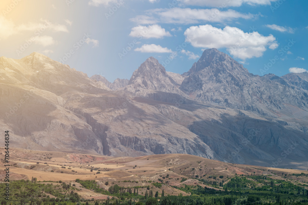 Fototapeta premium Red mountains the extension of the Taurus Mountains the harmony of the sunset coloured clouds and the steep rocks of its surroundings with the sky and sun light