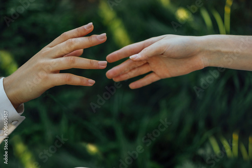 Close up of a woman's hand touching the grass, feeling nature