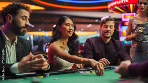 Diverse Group of People Playing Poker in a Luxurious Casino Championship. Private Club Guests Feeling Lucky, Placing Bets, Reading Opponents, Counting dealed cards, Calling Out Each Other for Bluffing photo