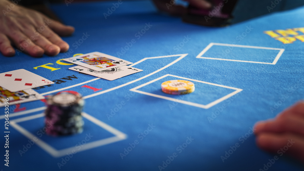 Fototapeta premium Close Up on Casino Baccarat Gambling Table: Anonymous Croupier Dealing Playing Cards on a Blackjack Table with Bet Chips in Place. Poker Chips are Being Exchanged as the Lucky Guest Wins the Jackpot