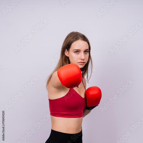 Woman boxer in gloves training on grey and yellow background studio © Ivan Zelenin