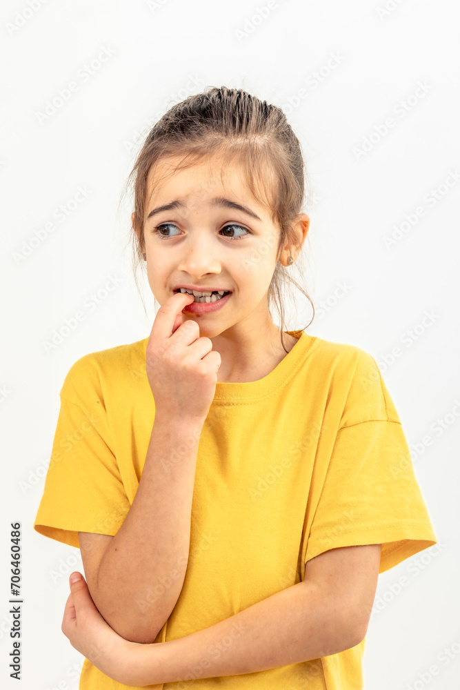 Scared and anxious girl, biting her fingernails on a white background isolated. Scared and anxious girl, biting her fingernails on a white background isolated.