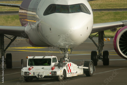 Tow tractor pushes the passenger airplane. Pushback tractor with Aircraft on the runway in airport.