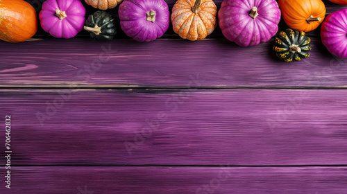 A group of pumpkins on a vivid purple color wood boards