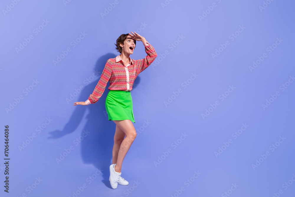 Full length photo of ecstatic impressed girl wear green skirt hand on forehead look at sale empty space isolated on blue color background Full length photo of ecstatic impressed girl wear green skirt hand on forehead look at sale empty space isolated on blue color background