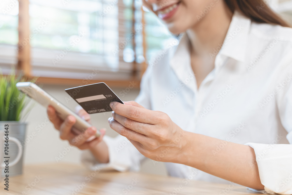 Happy Asian young woman using mobile phone shopping online and pay via credit card to get cashback bonus. Happy Asian young woman using mobile phone shopping online and pay via credit card to get cashback bonus.