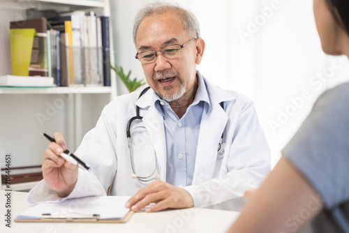 Close up doctor talking with the patient at a desk in the clinic