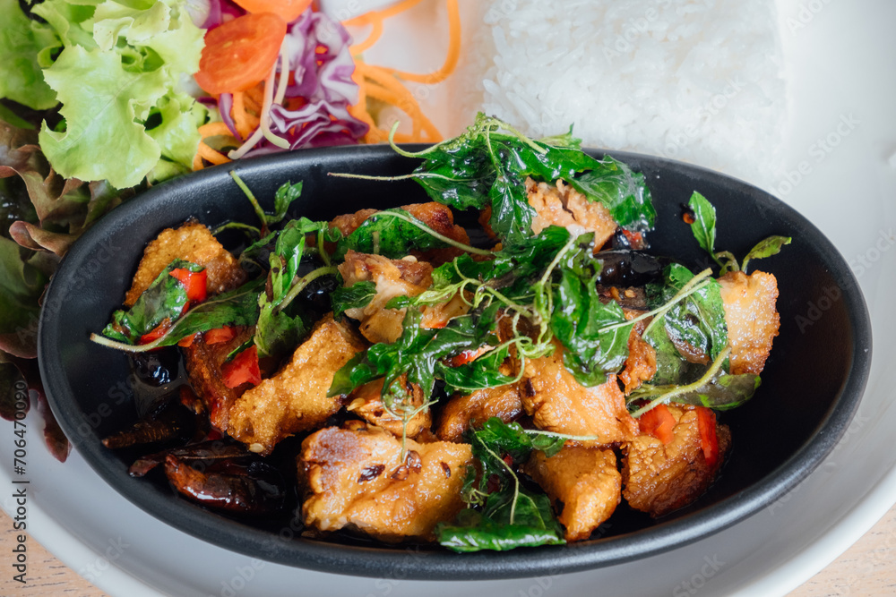 Fototapeta premium Stir-Fried Crispy Pork with Thai Basil is a popular Thai dish that is made with crispy pork belly, 