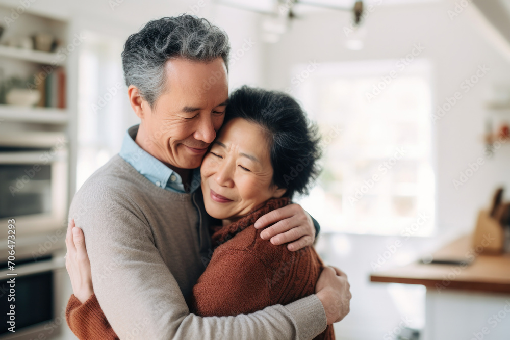 Affectionate elderly Asian couple, married for decades, share a loving embrace at home. Affectionate elderly Asian couple, married for decades, share a loving embrace at home.