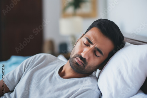 A peaceful, sleepy man lies in a comfortable bed, seeking rest and relaxation at home.