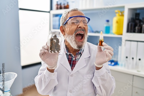 Frustrated and furious mature man scream in anger at laboratory, strong expression of rage over cannabis medicine photo