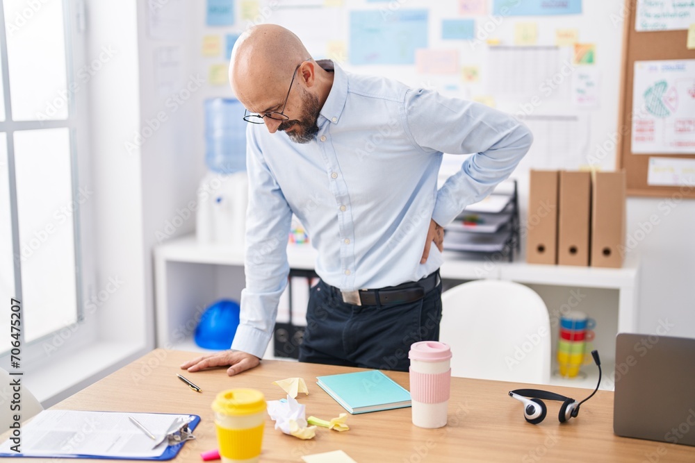 Young bald man business worker suffering for backache at office