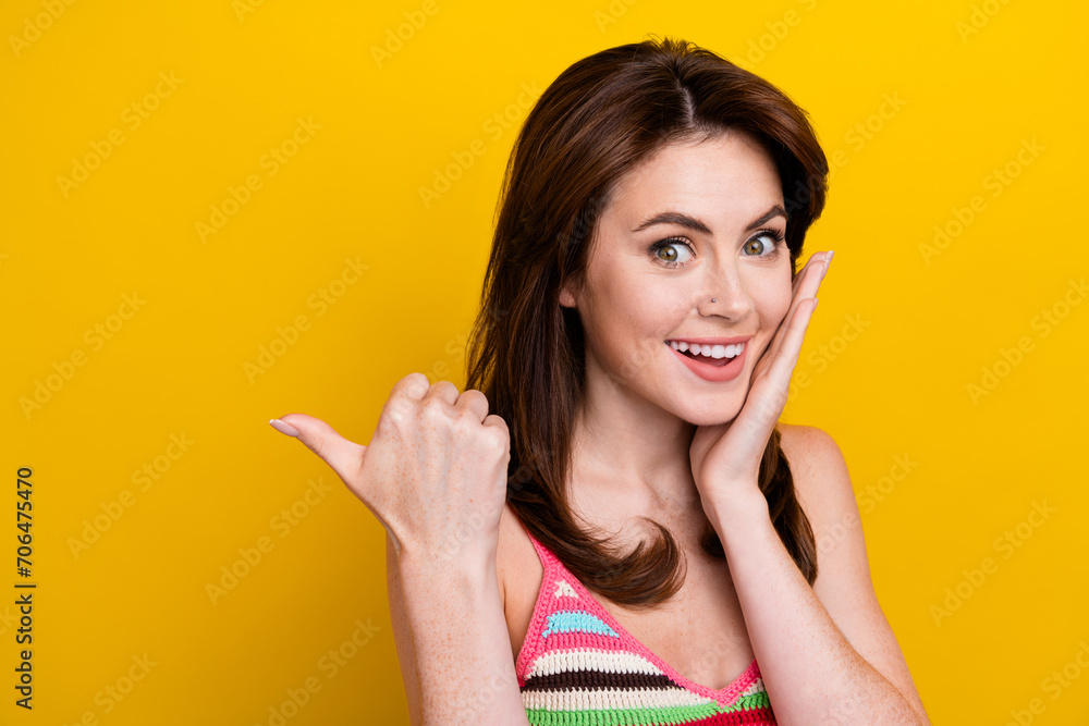 Portrait of impressed woman directing at unbelievable discount empty space hand on cheekbone isolated on vivid yellow color background Portrait of impressed woman directing at unbelievable discount empty space hand on cheekbone isolated on vivid yellow color background