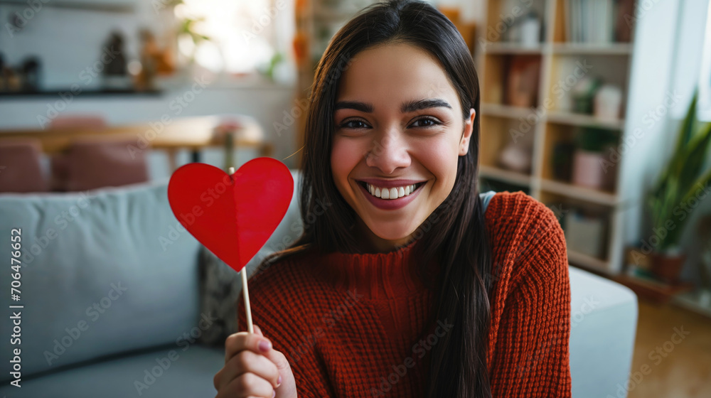 Happy Hispanic teenager girl holding a heart smiling at camera, at home. Happy Hispanic teenager girl holding a heart smiling at camera, at home.