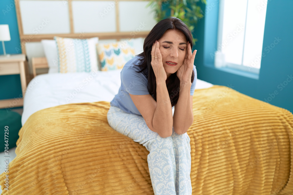 Middle age hispanic woman stressed sitting on bed at bedroom Middle age hispanic woman stressed sitting on bed at bedroom