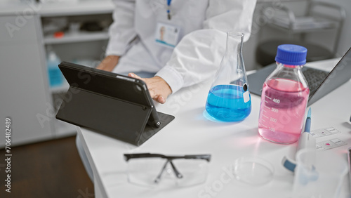Caucasian woman scientist analyzing data on tablet in modern laboratory
