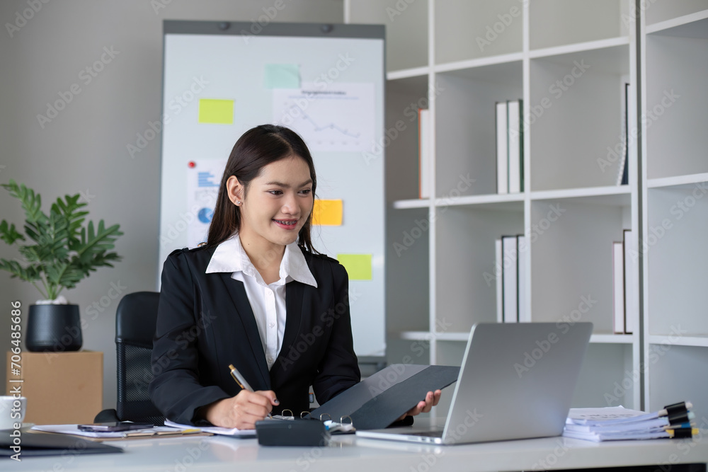 Business documents, business auditor Asian woman is reviewing legal documents, preparing documents or reports for analysis tax accountant documents agreement contract information in office at work Business documents, business auditor Asian woman is reviewing legal documents, preparing documents or reports for analysis tax accountant documents agreement contract information in office at work