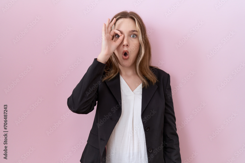 Young caucasian business woman wearing black jacket doing ok gesture shocked with surprised face, eye looking through fingers. unbelieving expression. Young caucasian business woman wearing black jacket doing ok gesture shocked with surprised face, eye looking through fingers. unbelieving expression.