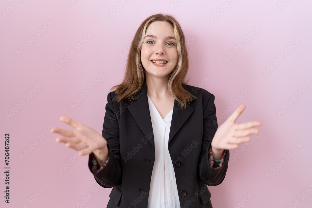 Young caucasian business woman wearing black jacket smiling cheerful offering hands giving assistance and acceptance. Young caucasian business woman wearing black jacket smiling cheerful offering hands giving assistance and acceptance.
