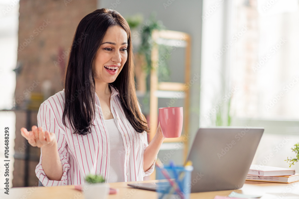 Portrait of cheerful entrepreneur girl hand hold coffee mug communicate video call laptop office desk indoors Portrait of cheerful entrepreneur girl hand hold coffee mug communicate video call laptop office desk indoors