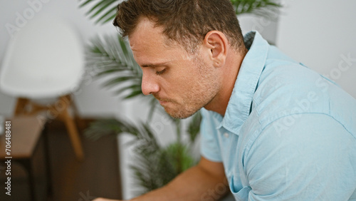 Φωτογραφία Contemplative hispanic man with beard, in casual attire, seated in a modern lobby