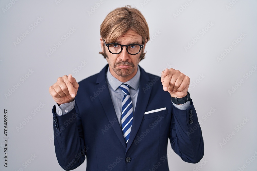 Caucasian man with mustache wearing business clothes pointing down looking sad and upset, indicating direction with fingers, unhappy and depressed. Caucasian man with mustache wearing business clothes pointing down looking sad and upset, indicating direction with fingers, unhappy and depressed.