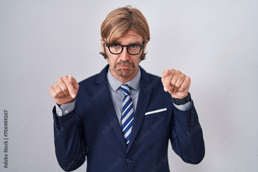 Caucasian man with mustache wearing business clothes pointing down looking sad and upset, indicating direction with fingers, unhappy and depressed.