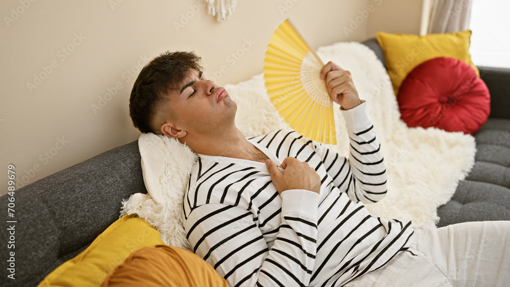 Handsome young hispanic man sweating from the heat, finds comfort in ...
