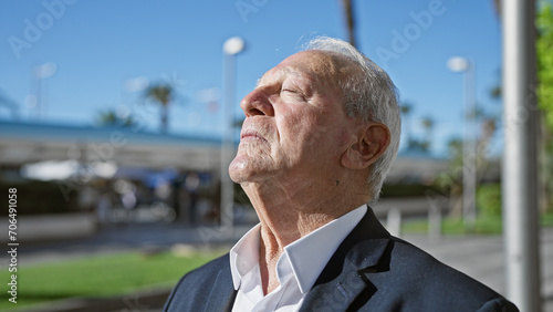 Foto Balanced senior man enjoying meditating, calmly breathing in the city street wit